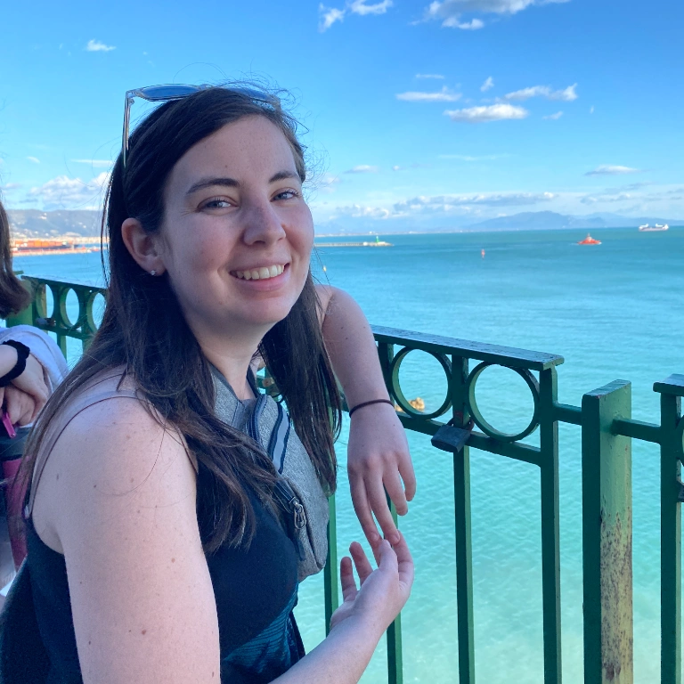A woman smiles while looking out over a seascape